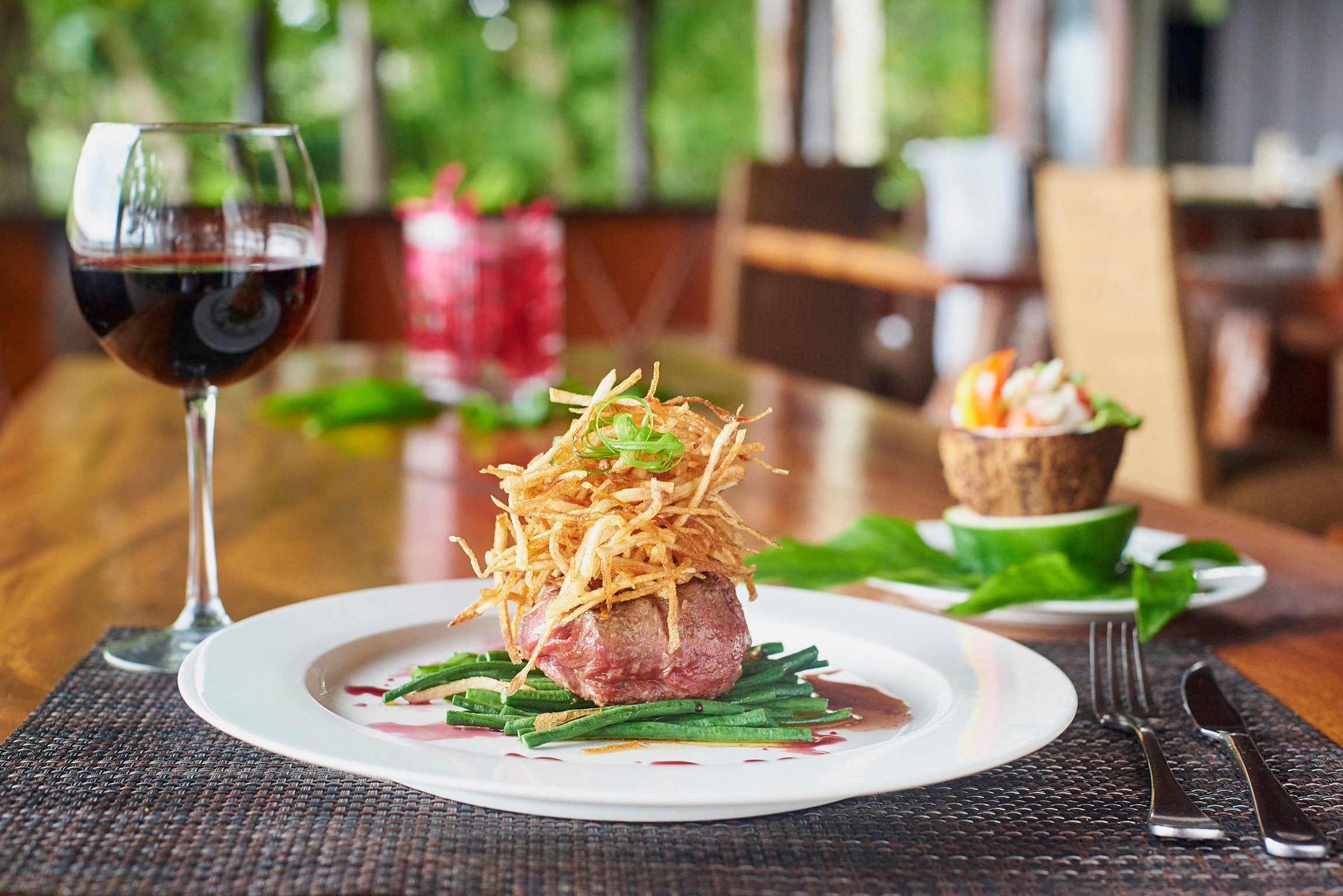 Plated main course and wine at Savasi Island Resort
