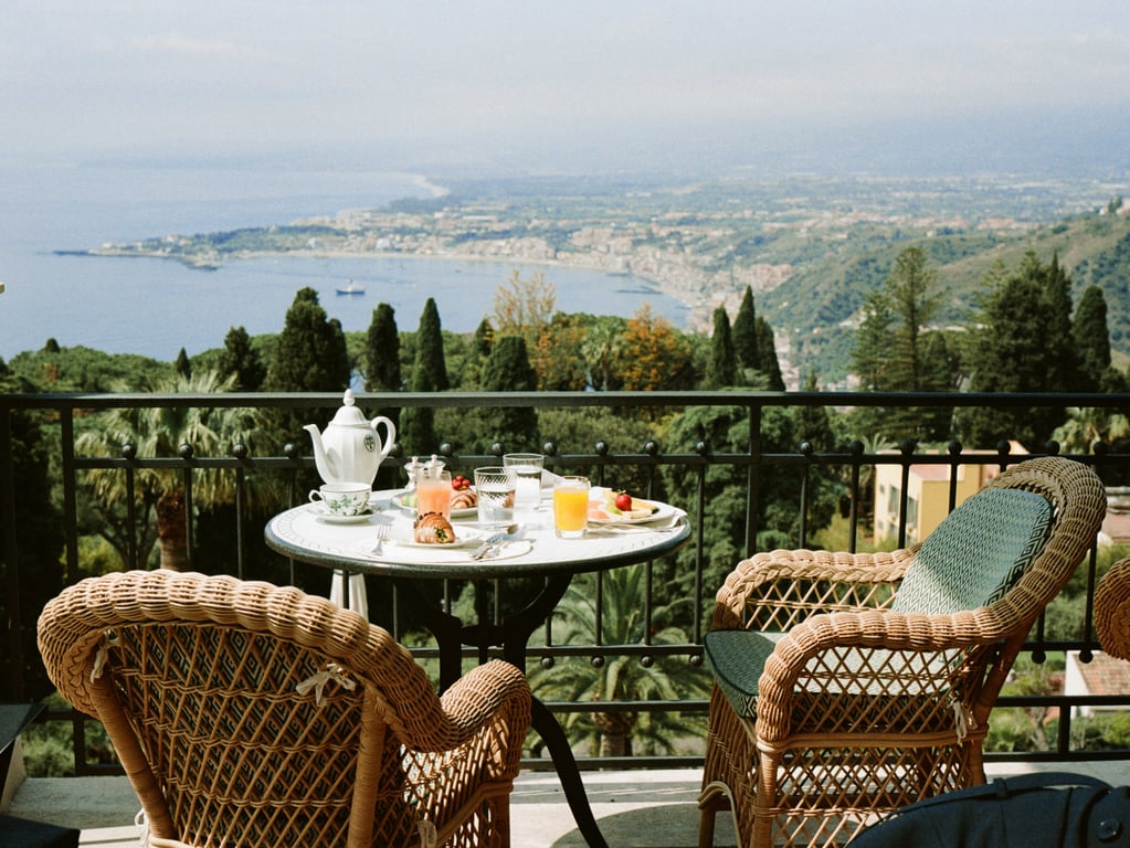 Breakfast table on a terrace overlooking the Sicilian coast