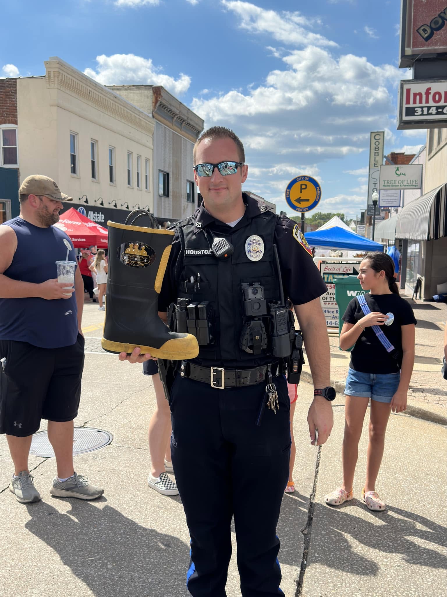 First responder holding a donation boot during a community fundraiser