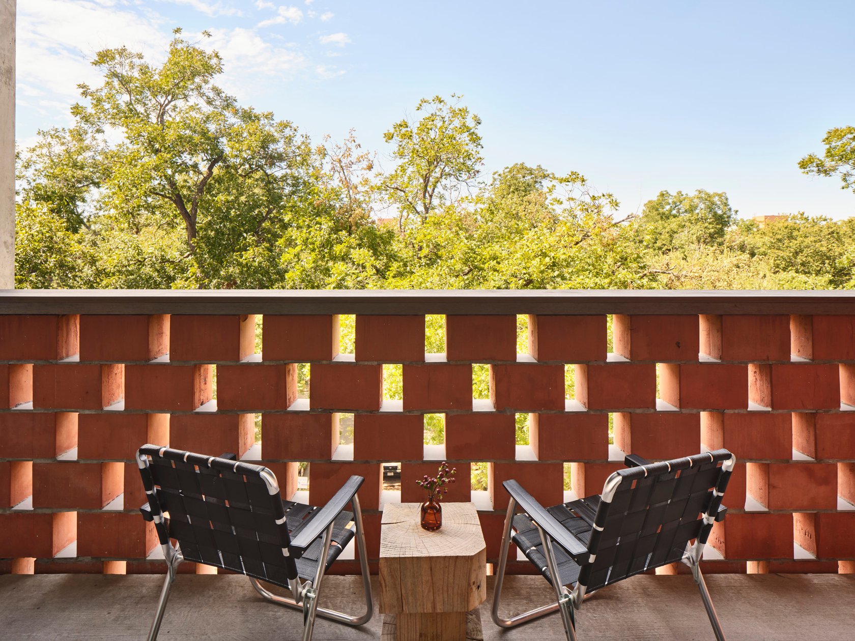 Private guest room terrace with brick screening at Carpenter Hotel
