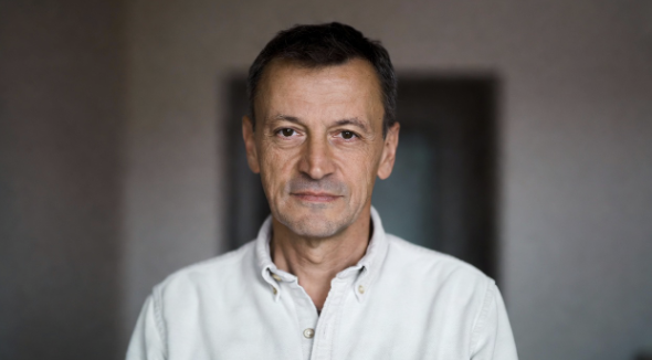 Man gently rolling shoulders while standing