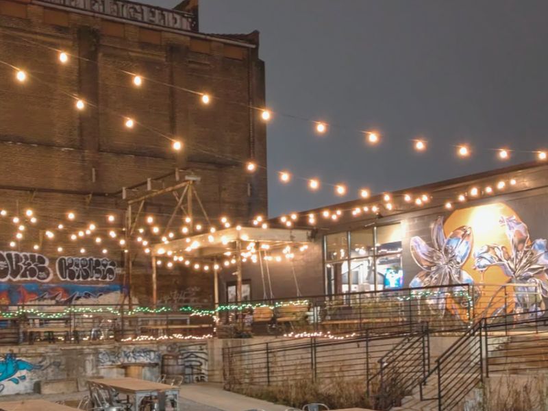 Gravel beer garden under string lights at Trellis Brewing
