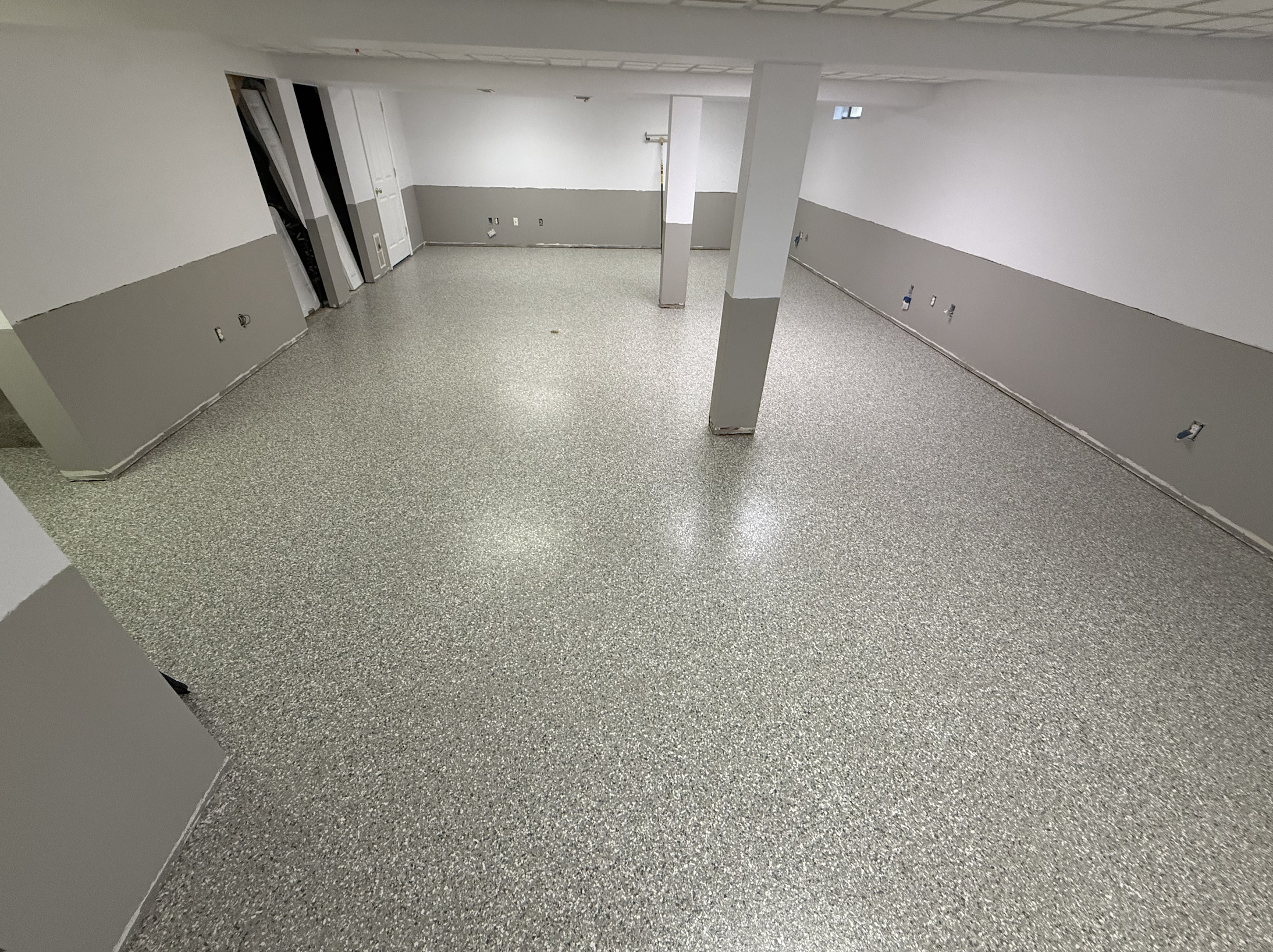 Finished basement renovation with support pillars