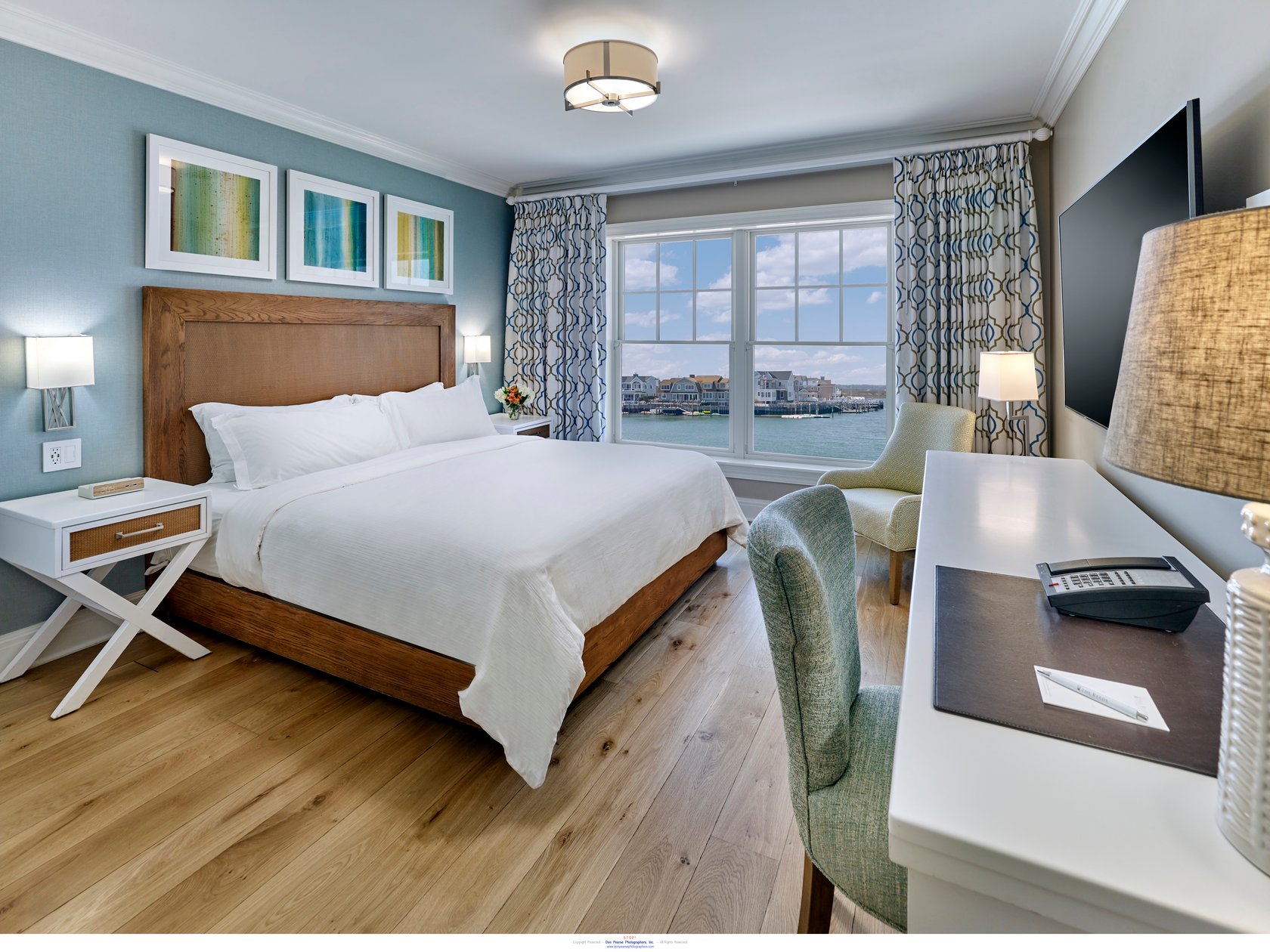 Bay-view guest room with a white bed and watery blue accents