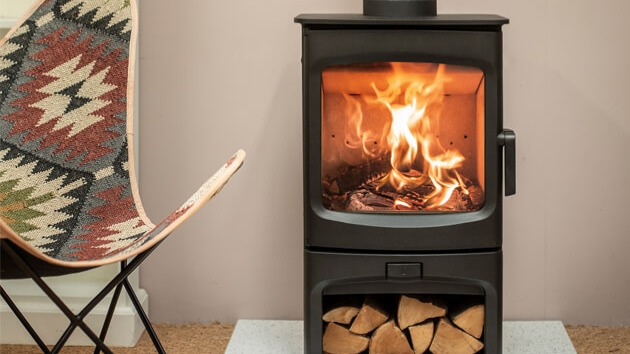 A lit Charnwood Aire stove in the manufacturer’s room photograph.