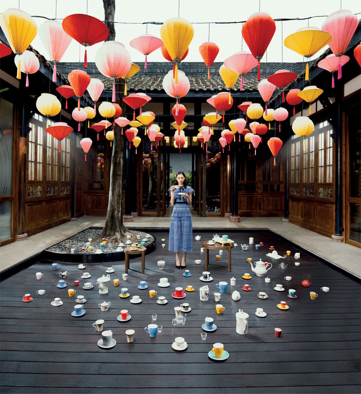 Colorful lantern art installation above a reflective courtyard pool