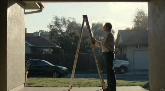 A steady ladder set on level ground with hands gripping the rungs
