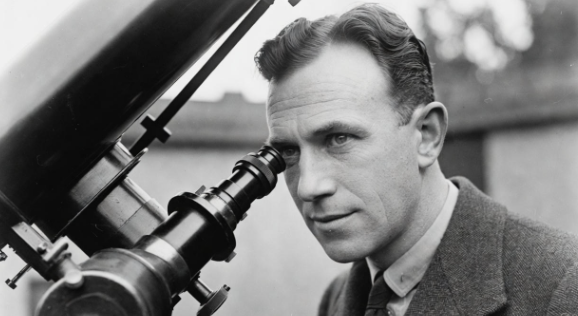 Edwin Hubble looking through a large telescope