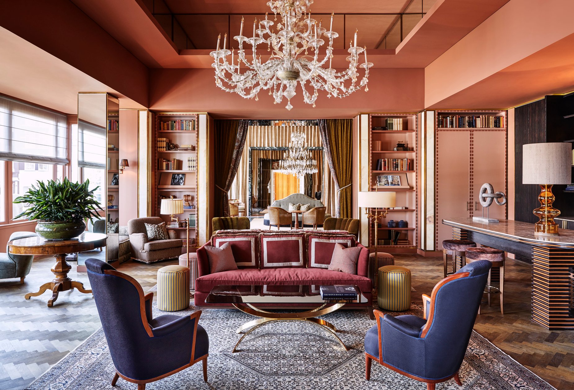 Chandelier and book-lined sitting room at Hotel De L’Europe Amsterdam