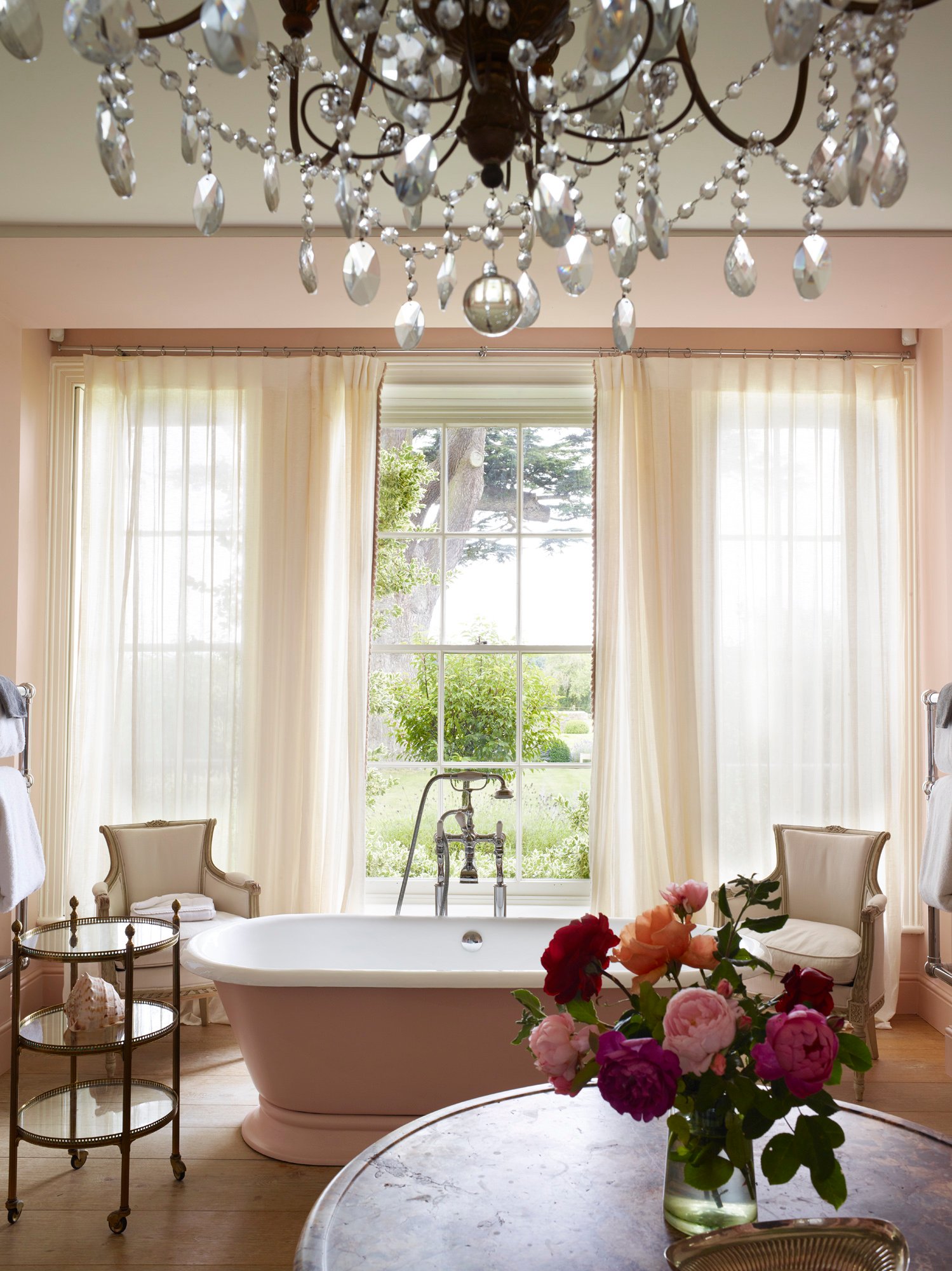 Pink freestanding bathtub beside the windows at Thyme