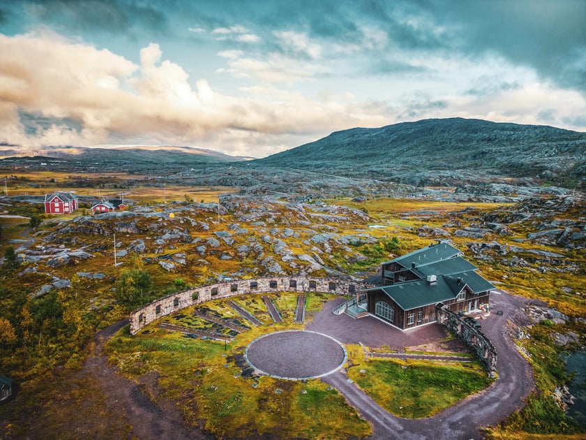 Niehku Mountain Villa and historic roundhouse ruins in the Arctic landscape