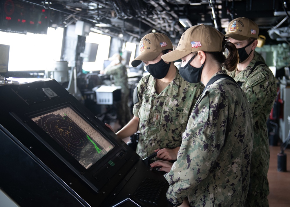 US Navy sailors standing bridge watch at a radar display