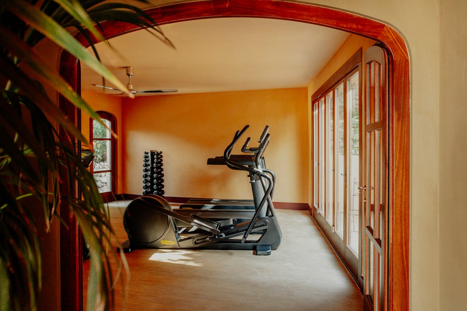 Fitness room with cardio equipment and garden views