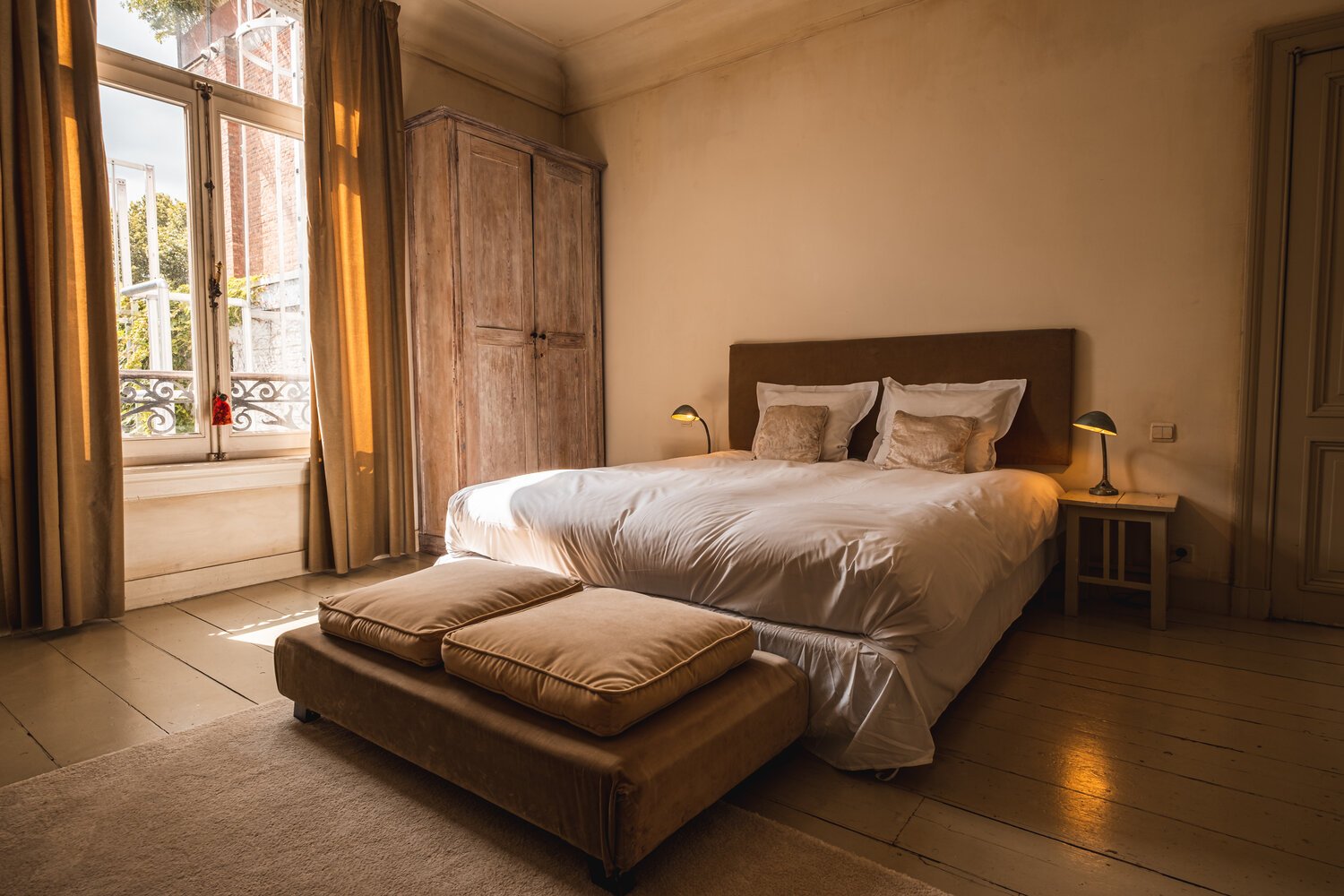 Guest room with tall windows at Boulevard Leopold Rooms and Suites