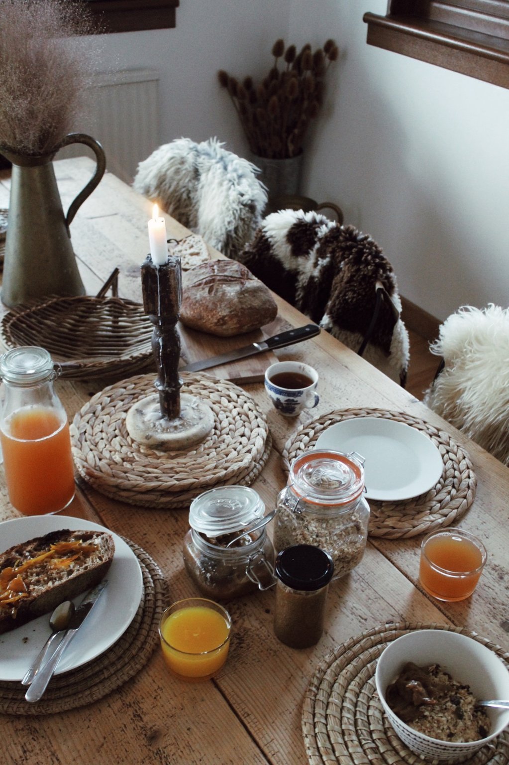 Farm breakfast spread with eggs, preserves, bread, juice, and tableware