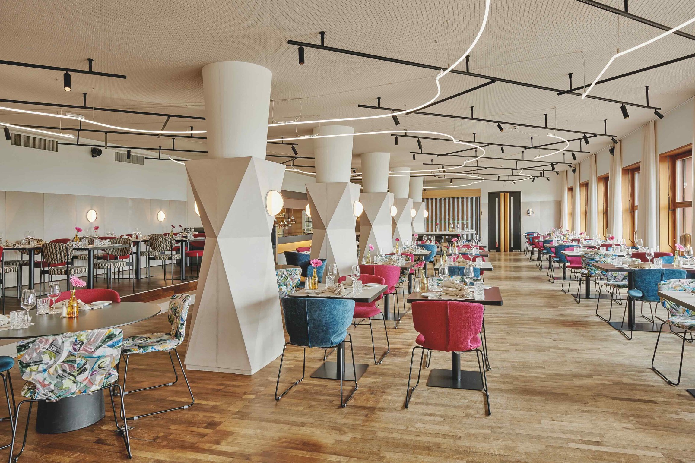 Bright restaurant with sculptural columns and patterned chairs