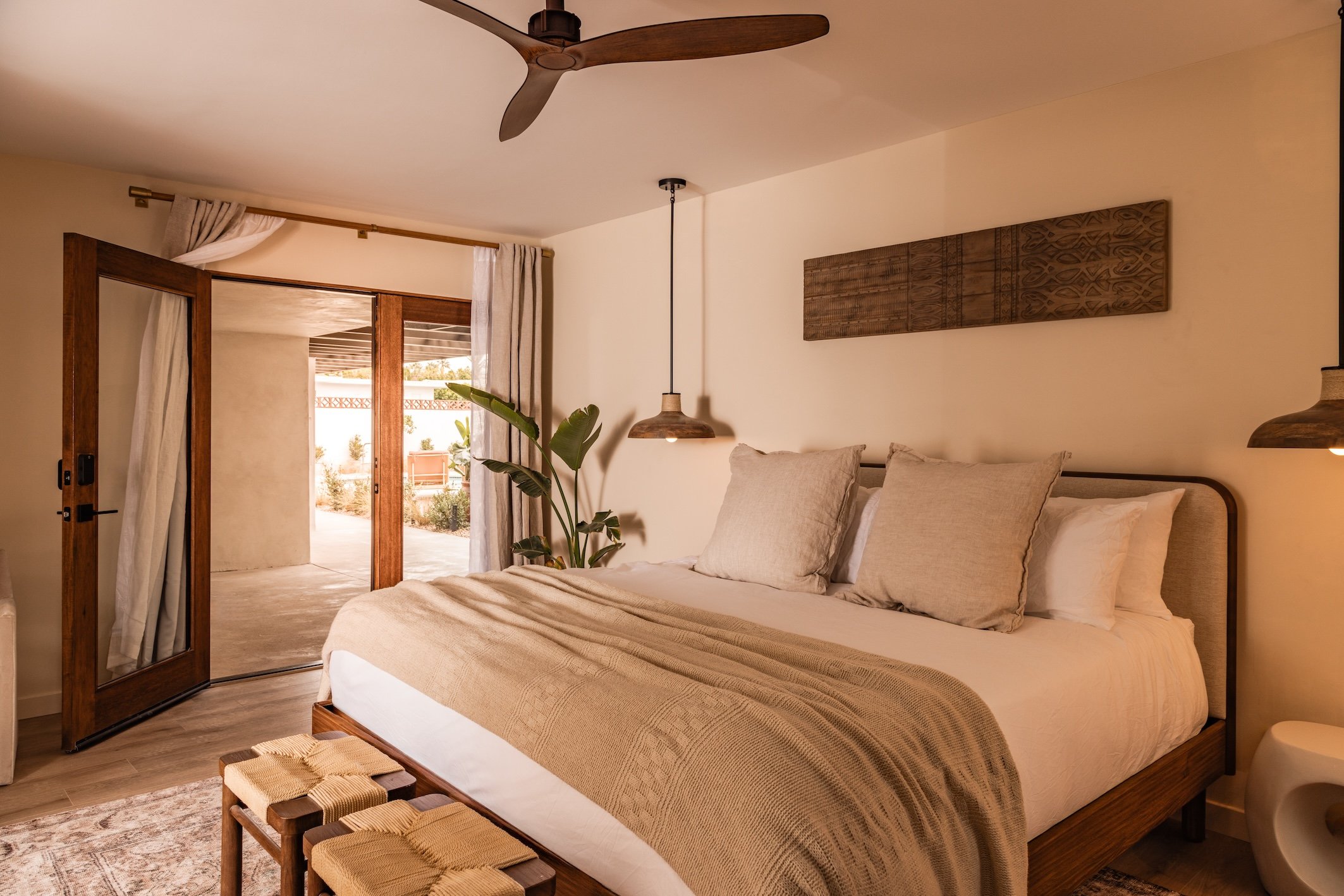 Neutral-toned guest room with wood furniture at Terra Palm Springs