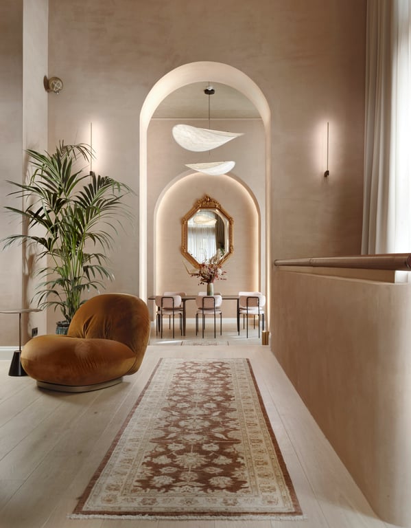 Arched hallway with contemporary seating and a patterned runner