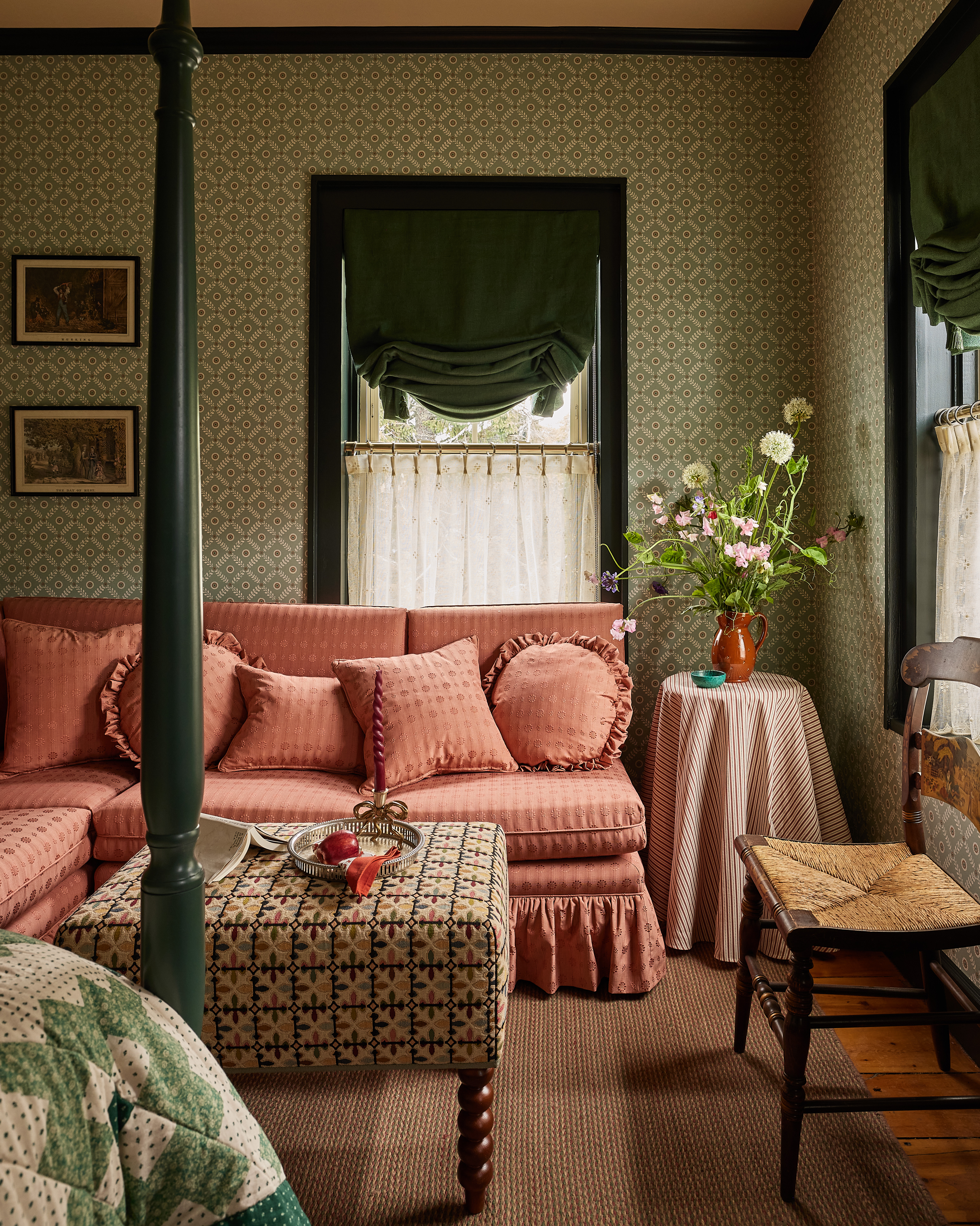 A salmon-pink sofa, patterned ottoman, green shades and fresh flowers in a sitting area at The Six Bells Countryside Inn.