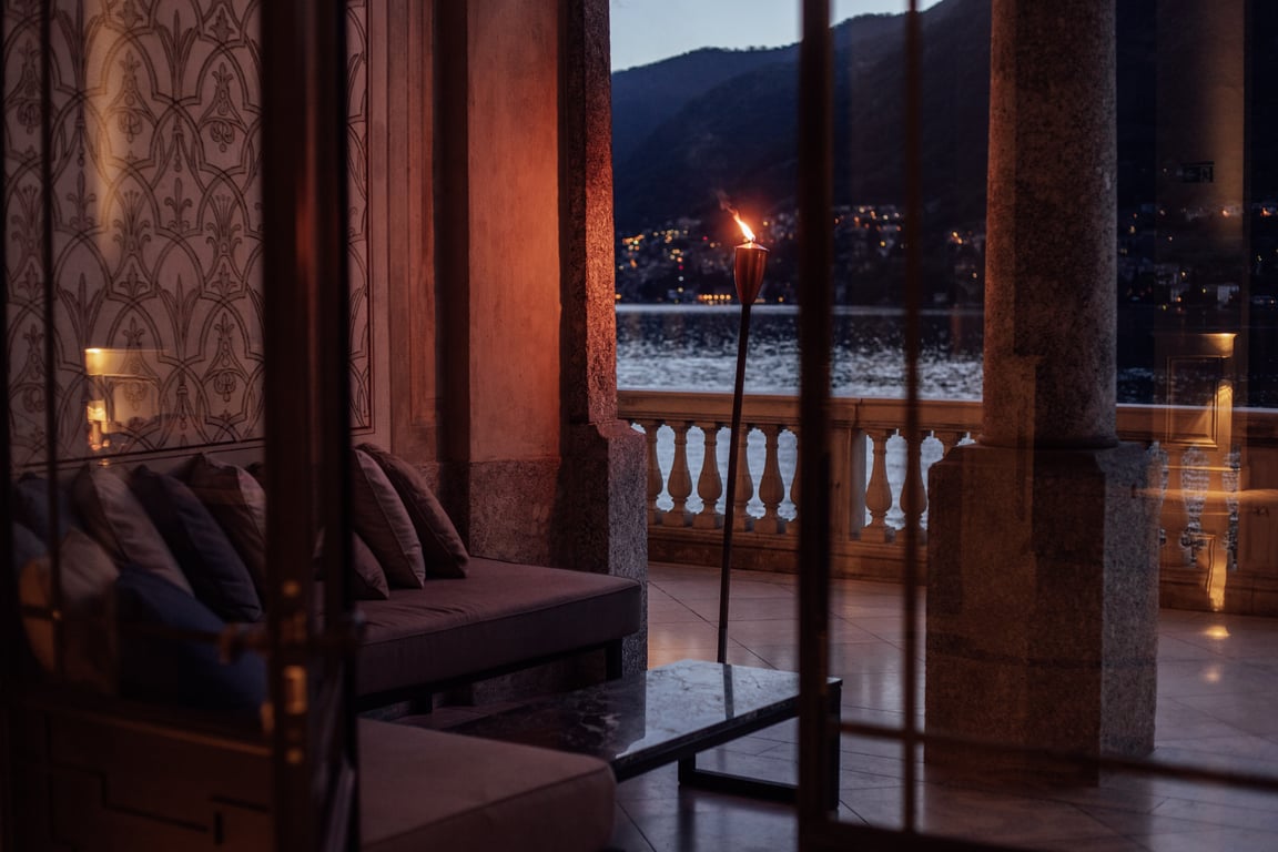 Villa Làrio lounge opening to a twilight lake view