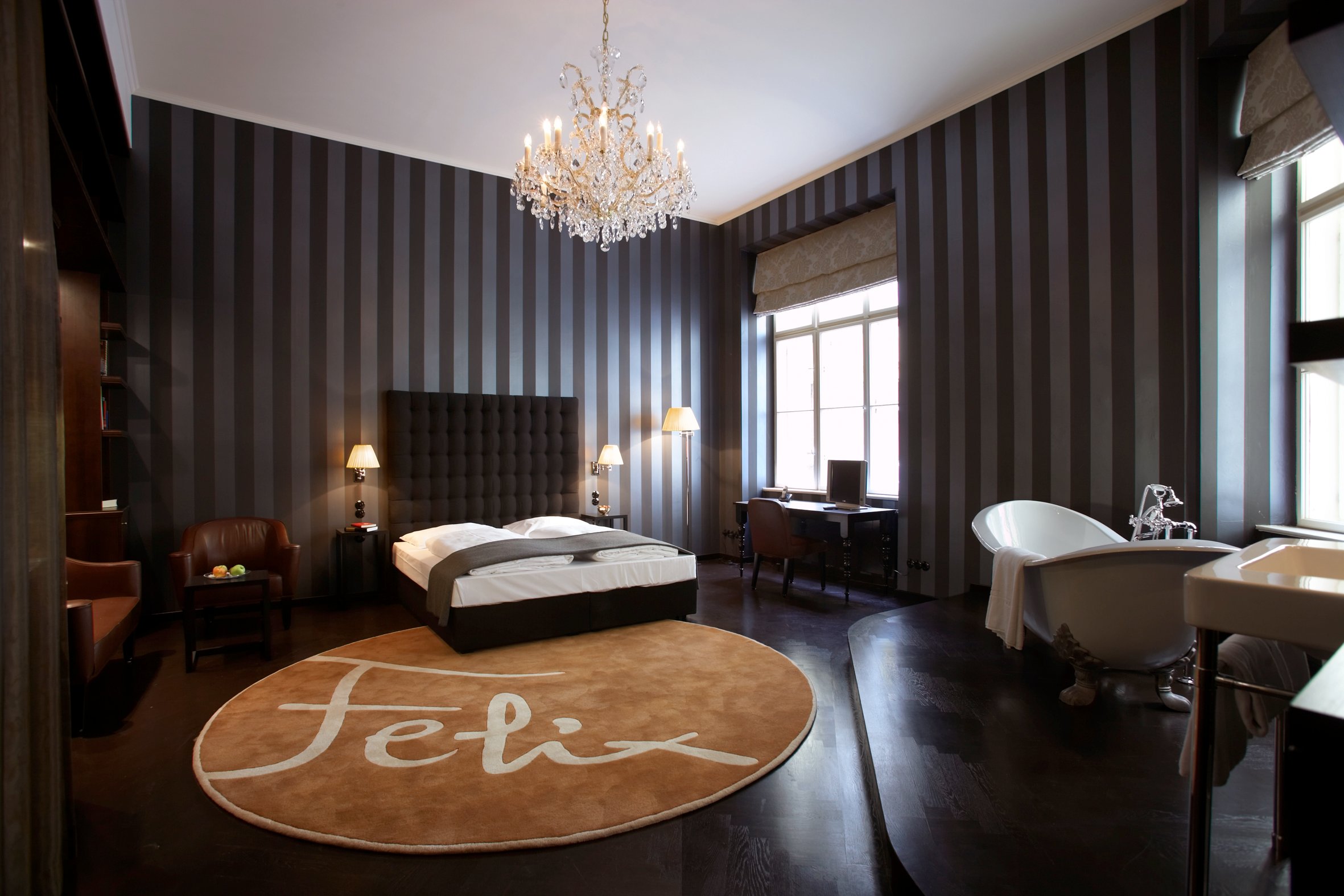 Guest room with chandelier and freestanding bathtub at Hotel Altstadt Vienna