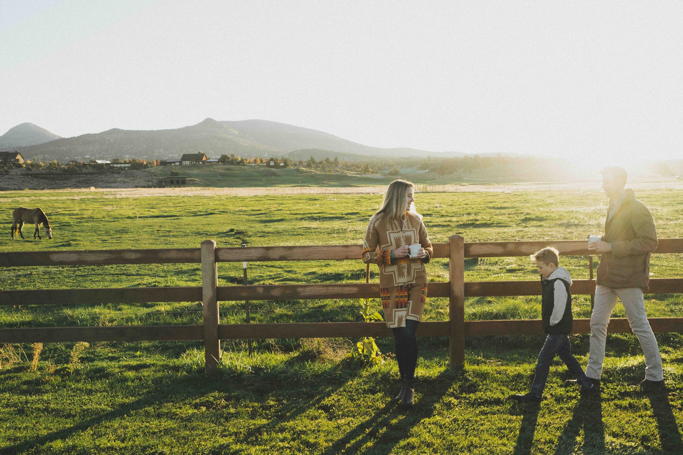 Family beside a pasture fence at Brasada Ranch