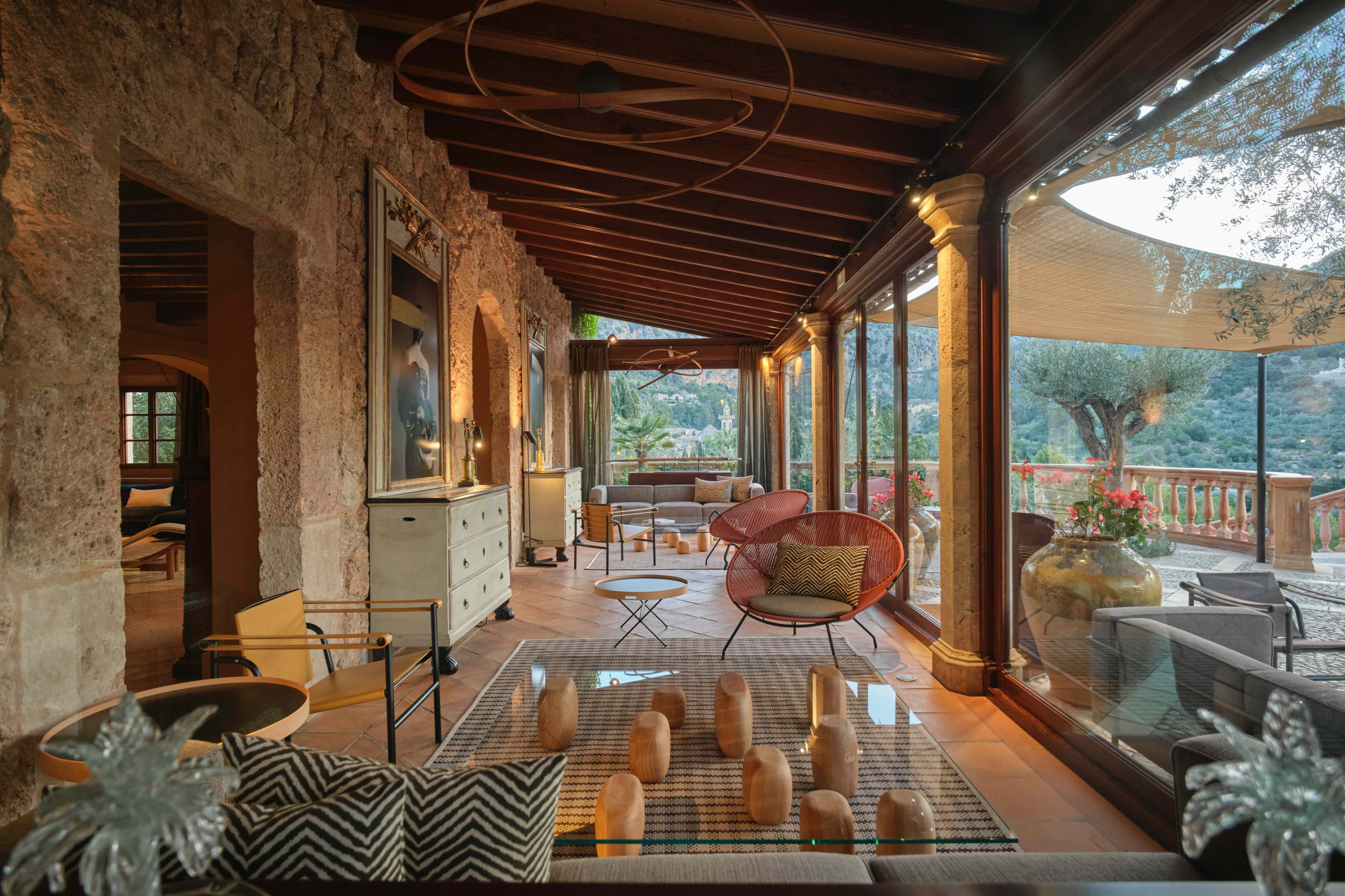 Covered stone terrace with woven seating and exposed beams