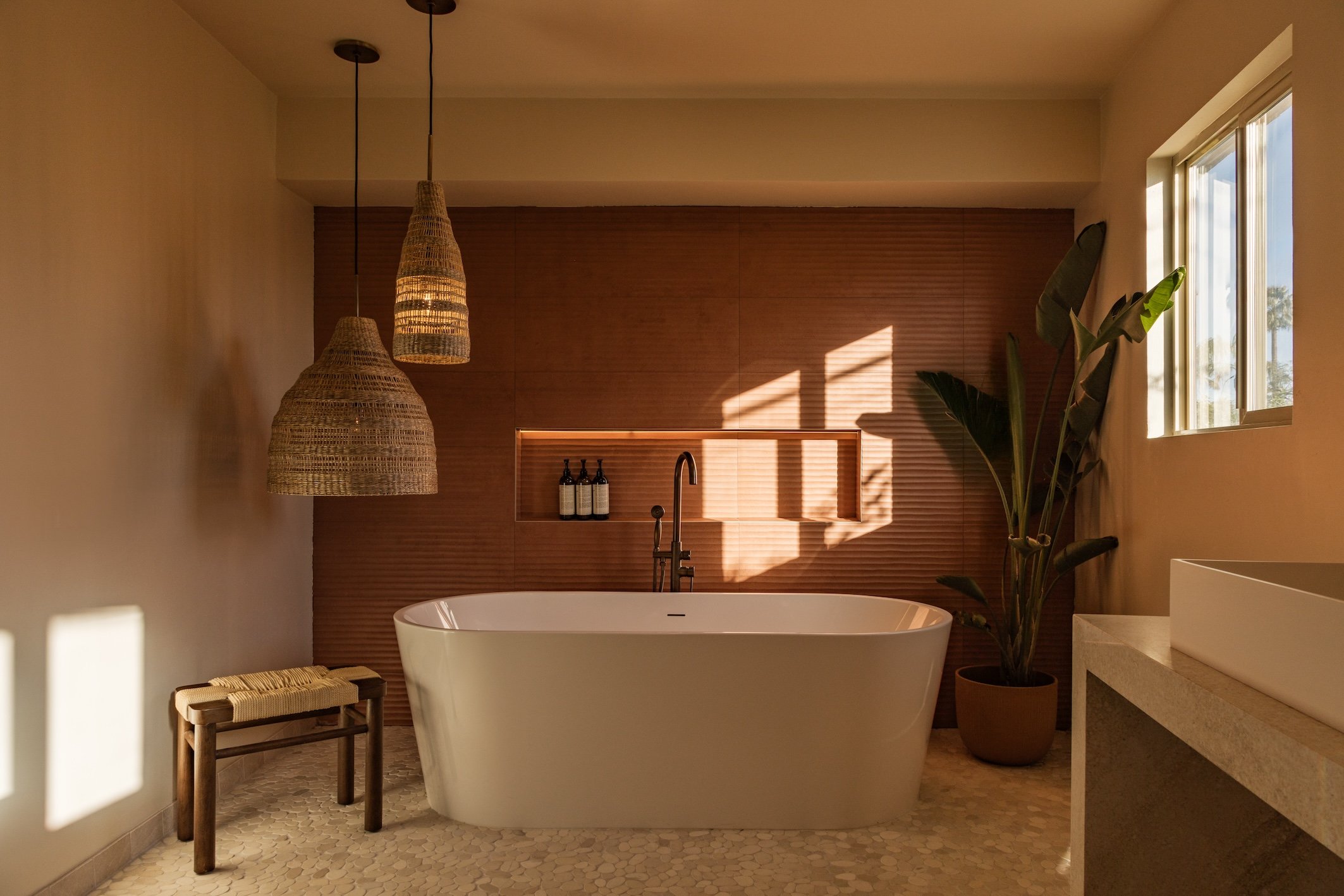 Freestanding bathtub in a sunlit bathroom at Terra Palm Springs