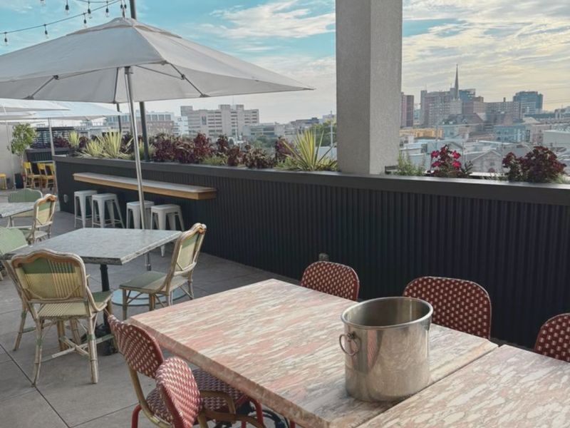 Rooftop tables and umbrellas with a view of downtown Louisville