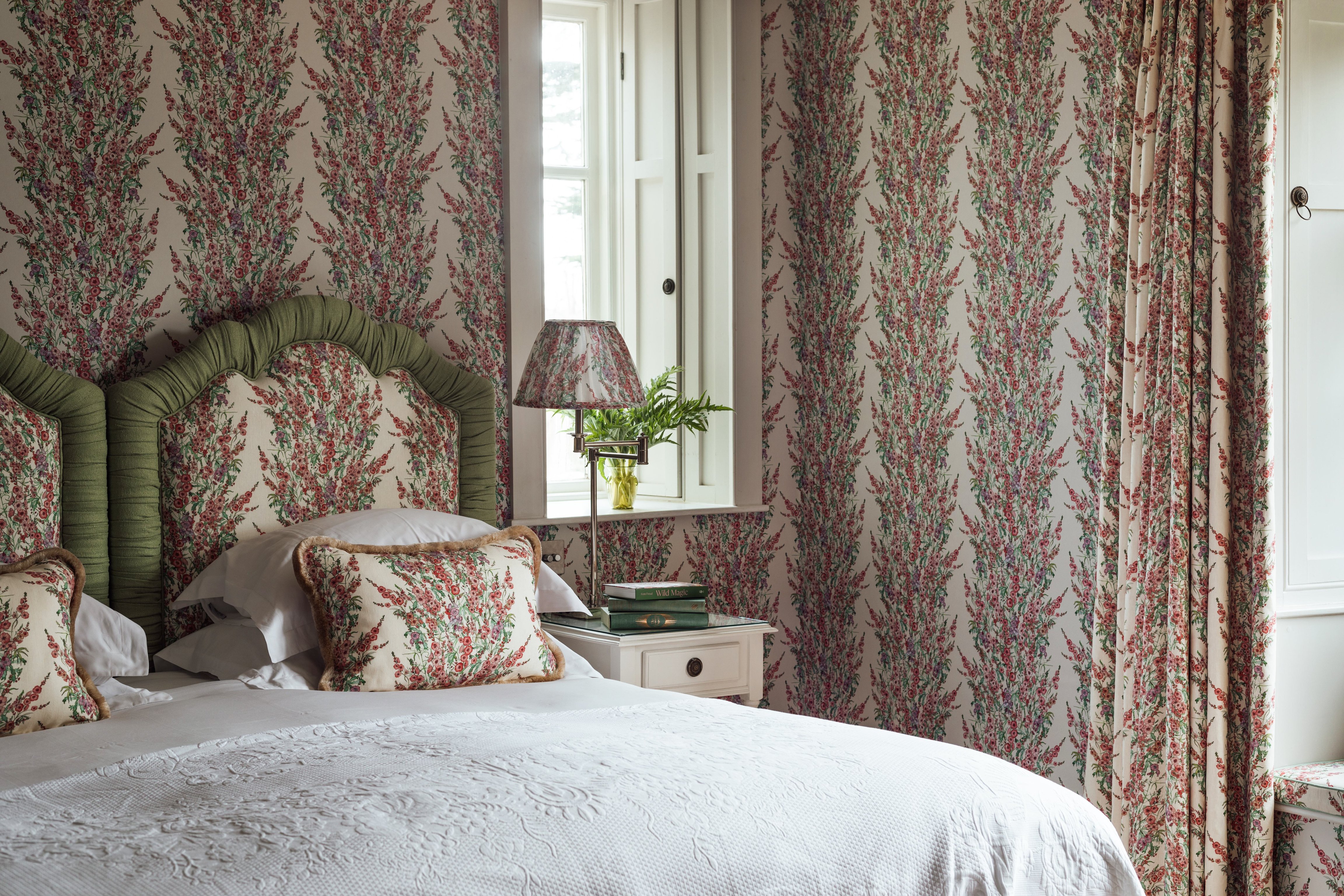 Floral wallpaper and upholstered headboard in a Thyme bedroom