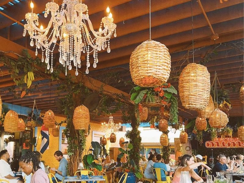 Covered patio with chandeliers, wicker lanterns and yellow chairs