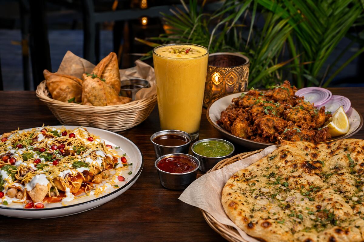 Indian street-food spread with chaat, samosas, pakoras, kulcha, chutneys and mango lassi