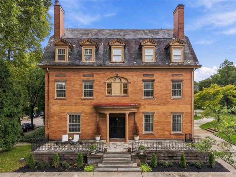 5238 Ellsworth Avenue: a three-story brick Colonial with a slate roof, five dormers and a columned entry