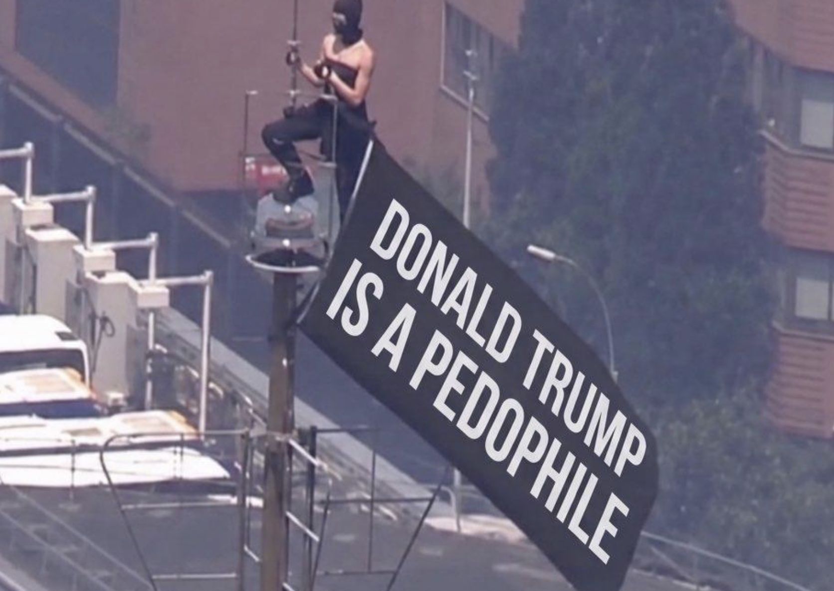 Two masked climbers on the Empire State Building spire holding a banner that AI redrew a dozen different ways