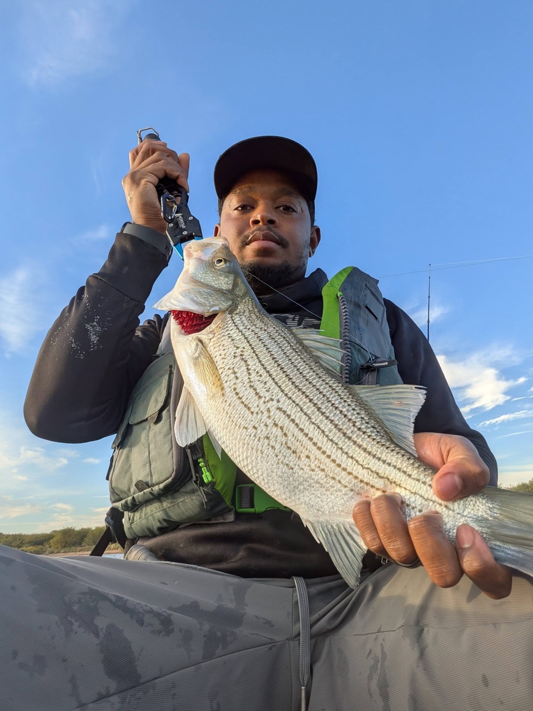 Ferdine Le Blanc holding a hybrid striped bass