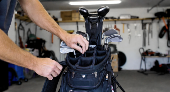Hands inspecting golf bag zippers and seams indoors