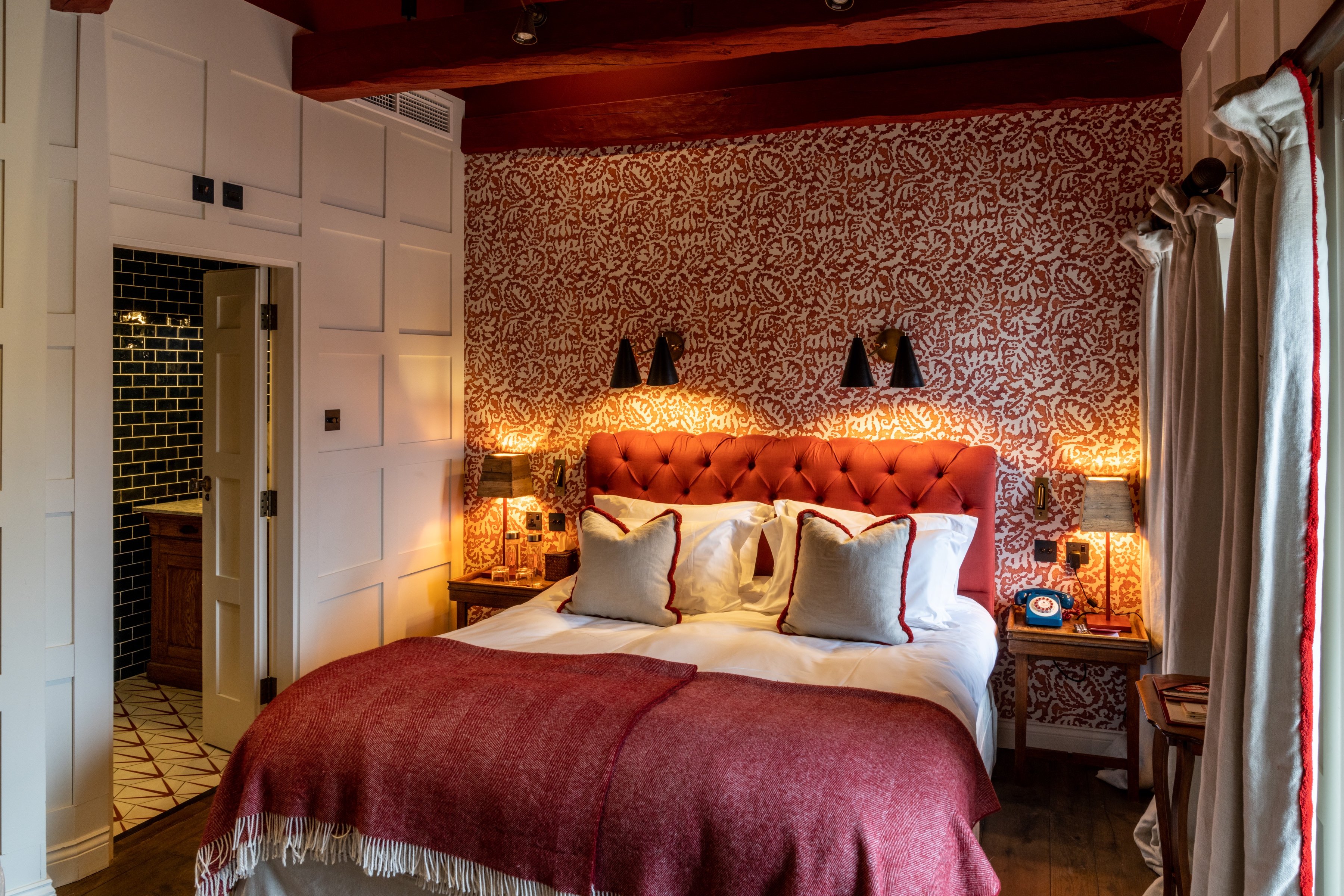 Colorful bedroom with a red upholstered headboard at The Double Red Duke