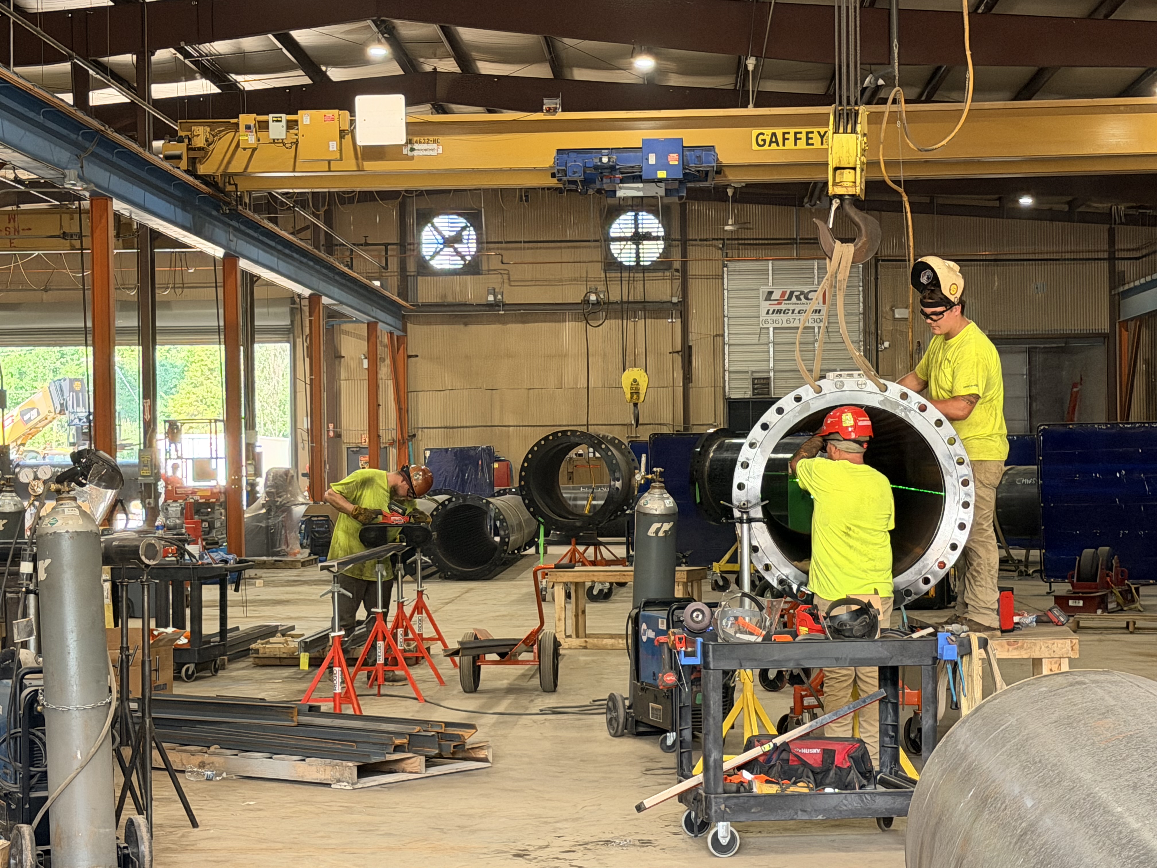 Icon Mechanical workers fitting large fabricated pipe