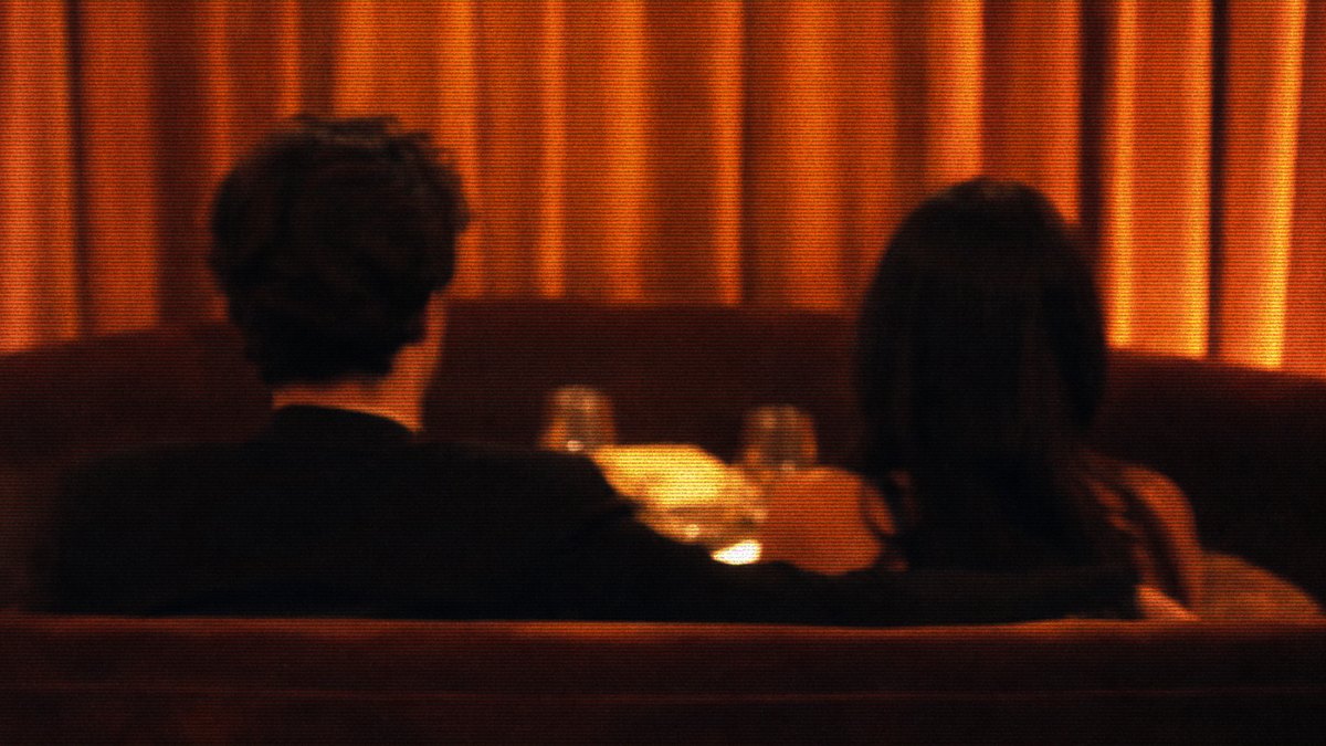 Two people dining side by side at a restaurant table