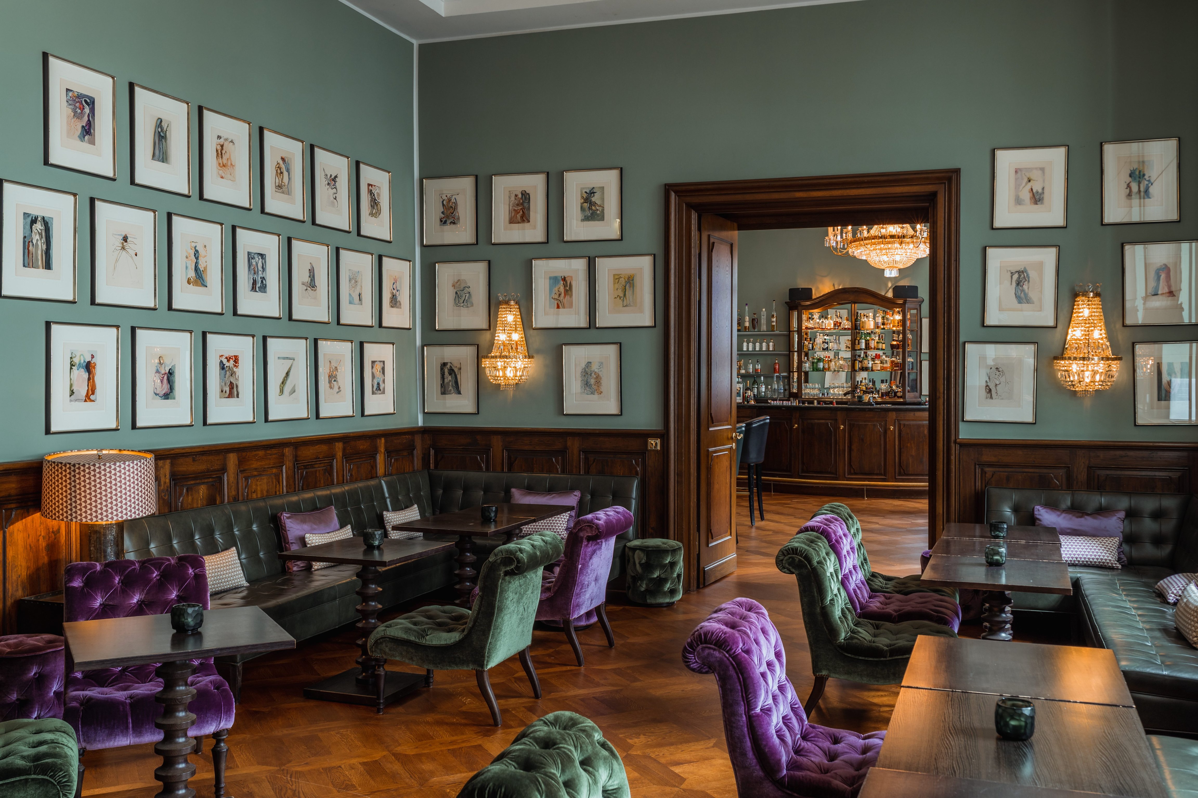 Salon with framed artwork and plush seating at Schloss Bensberg