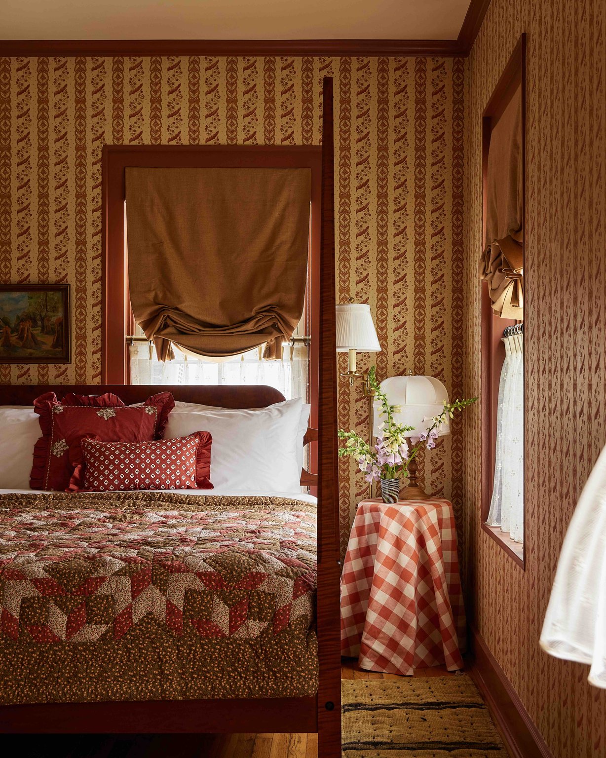 A patchwork quilt and floral wallpaper in a guest room at The Six Bells Countryside Inn.