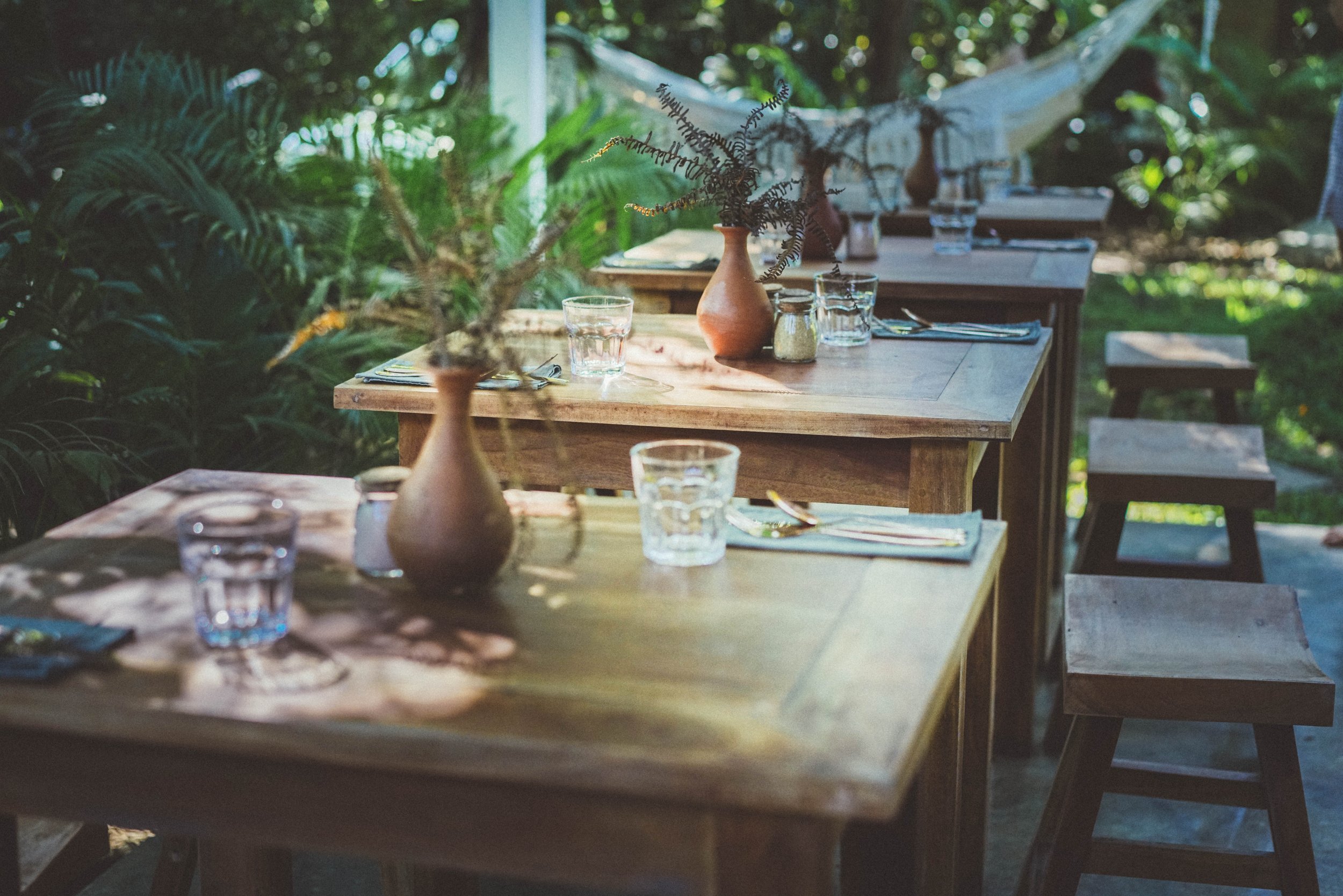 Outdoor tables set among the greenery at The Kip