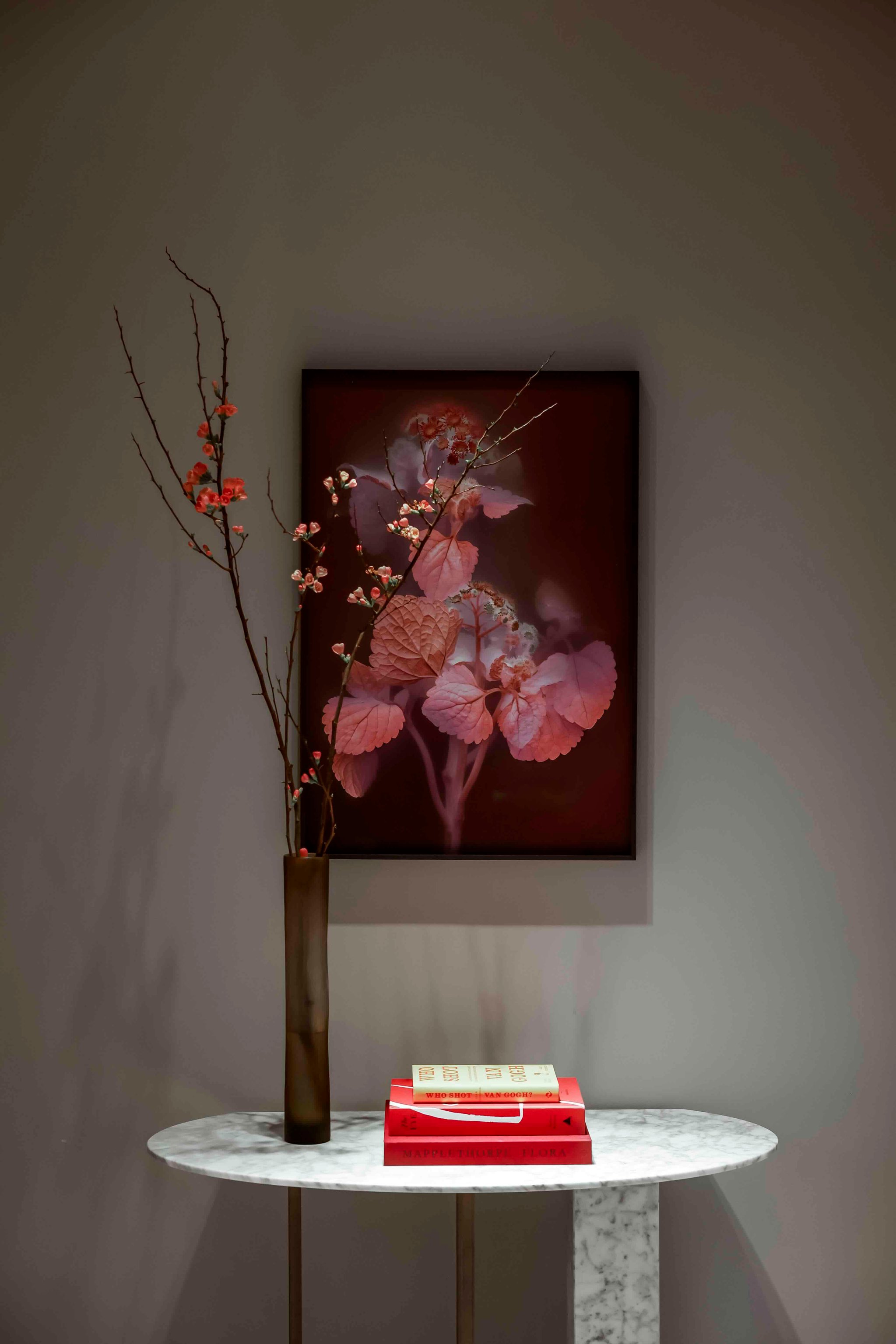 Artwork and flowers beside a sculptural side table
