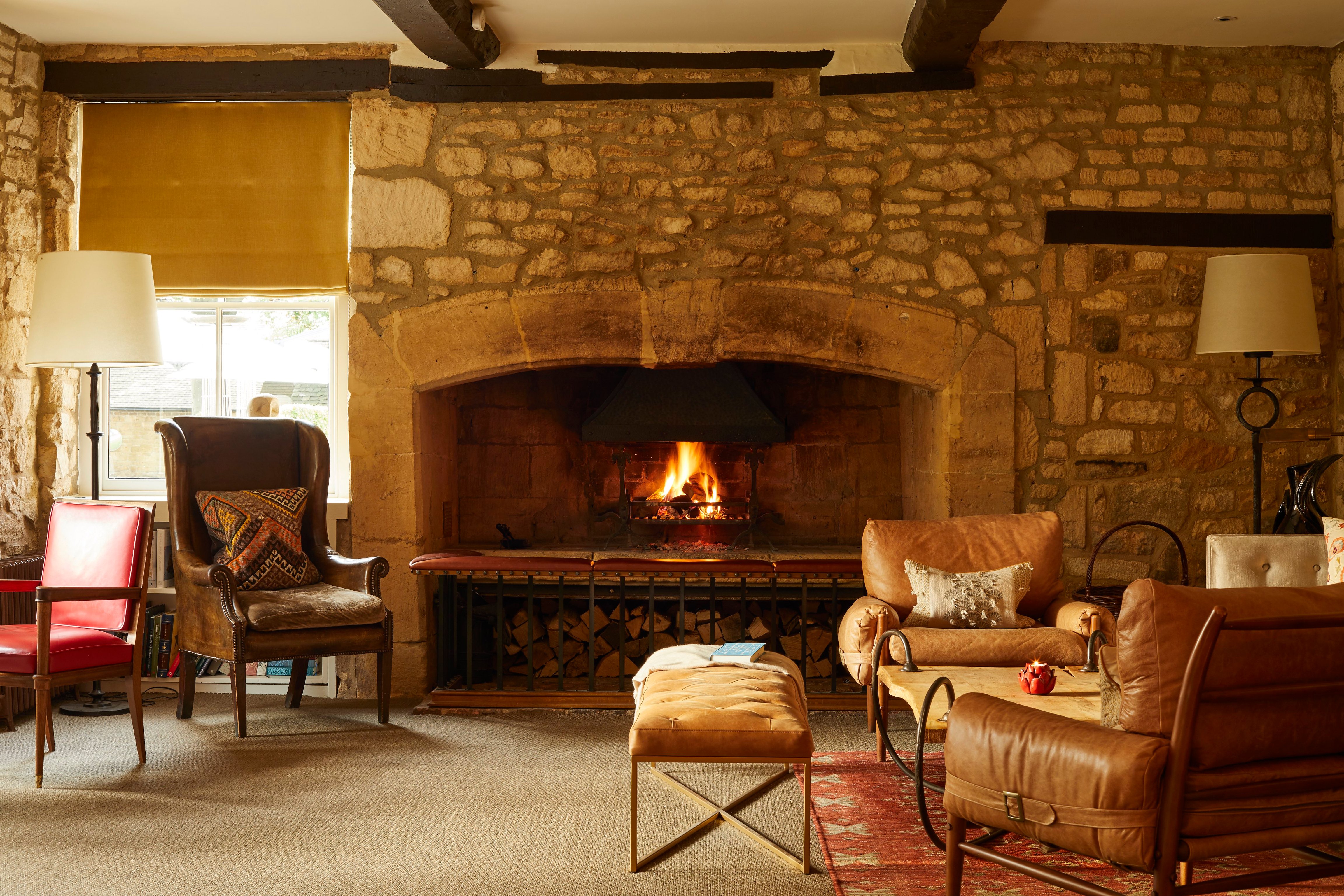Armchairs beside a large stone fireplace at Dormy House