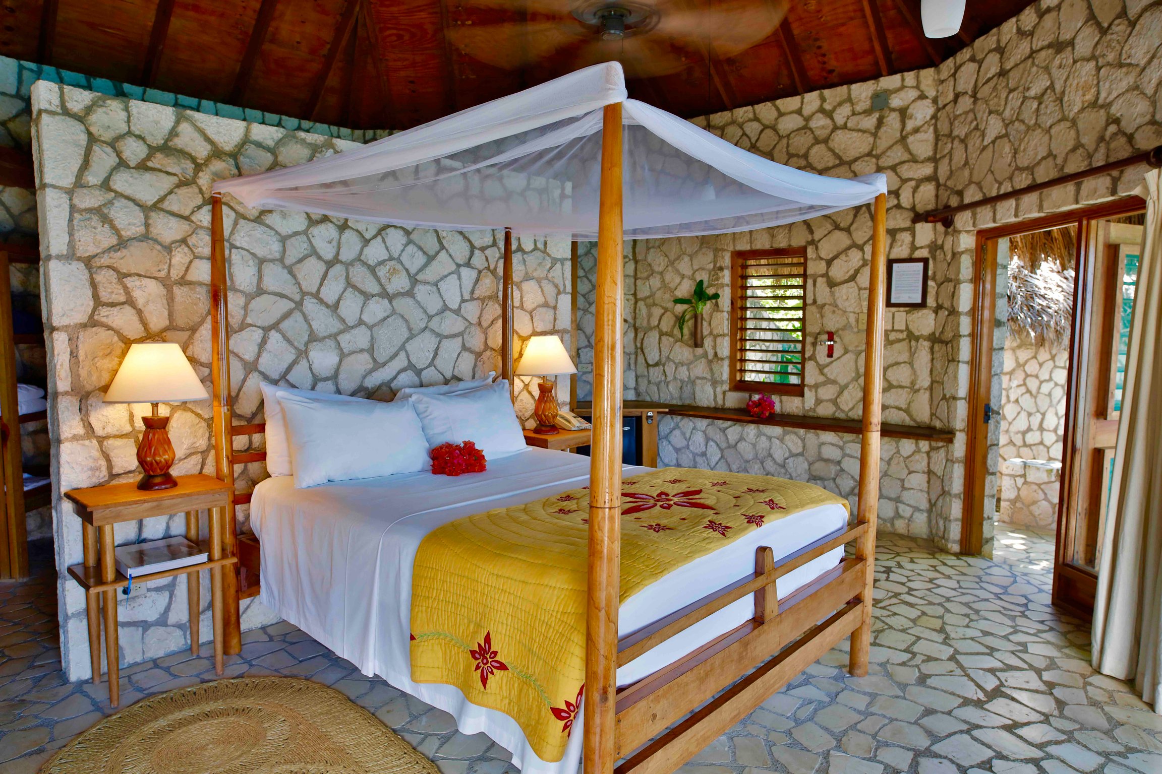 Stone-walled Rockhouse villa bedroom with a canopy bed
