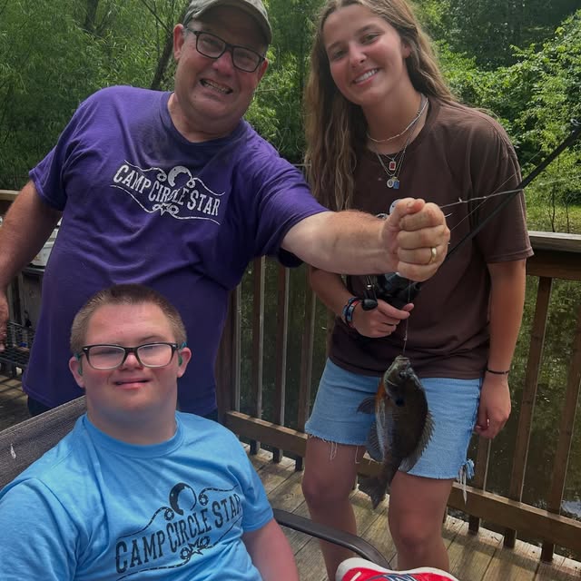 Camp Circle Star camper and volunteer holding a fish