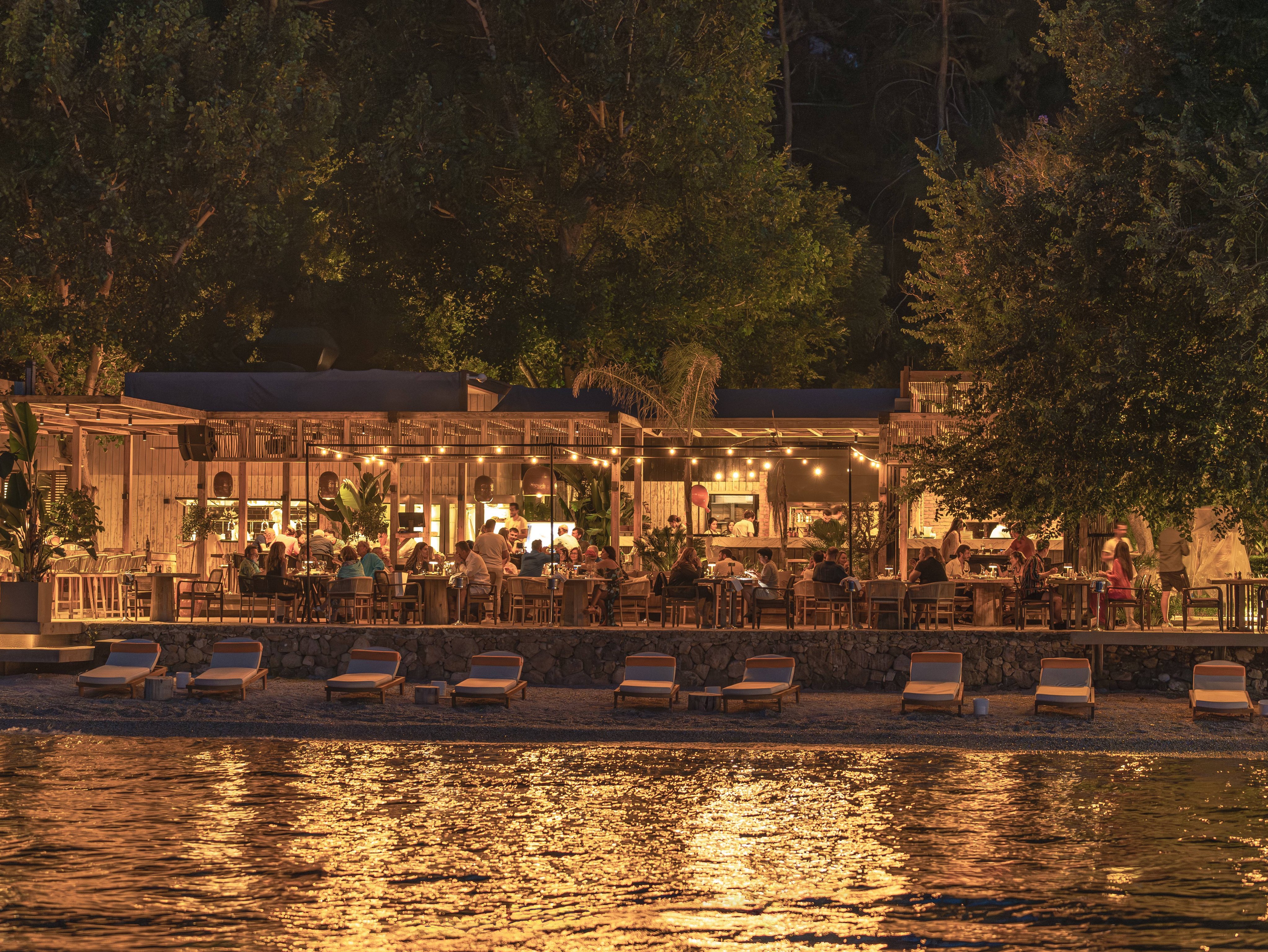 Yazz Collective restaurant illuminated beside the beach at night