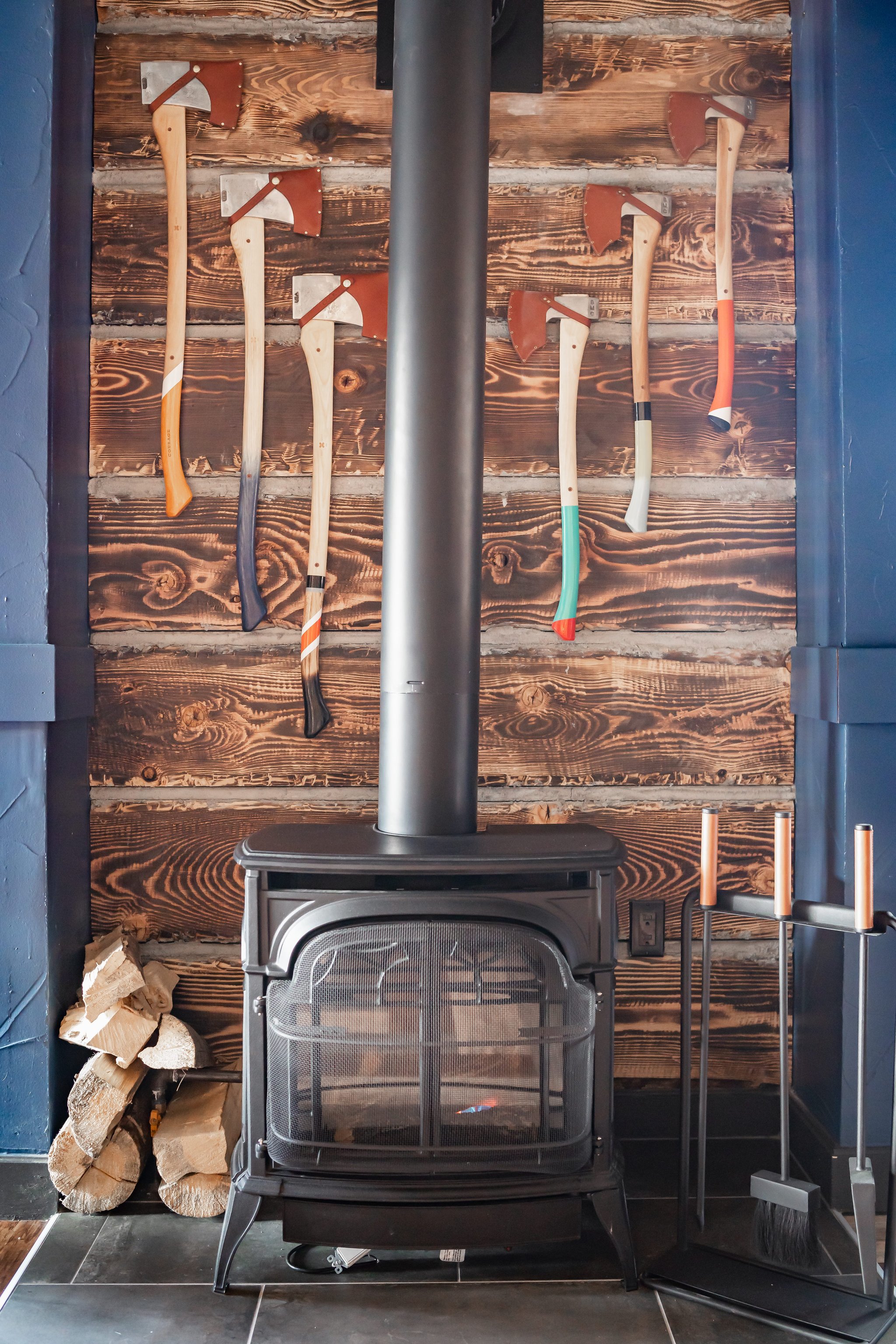 Wood-burning stove beneath vintage climbing tools at Gravity Haus Breckenridge