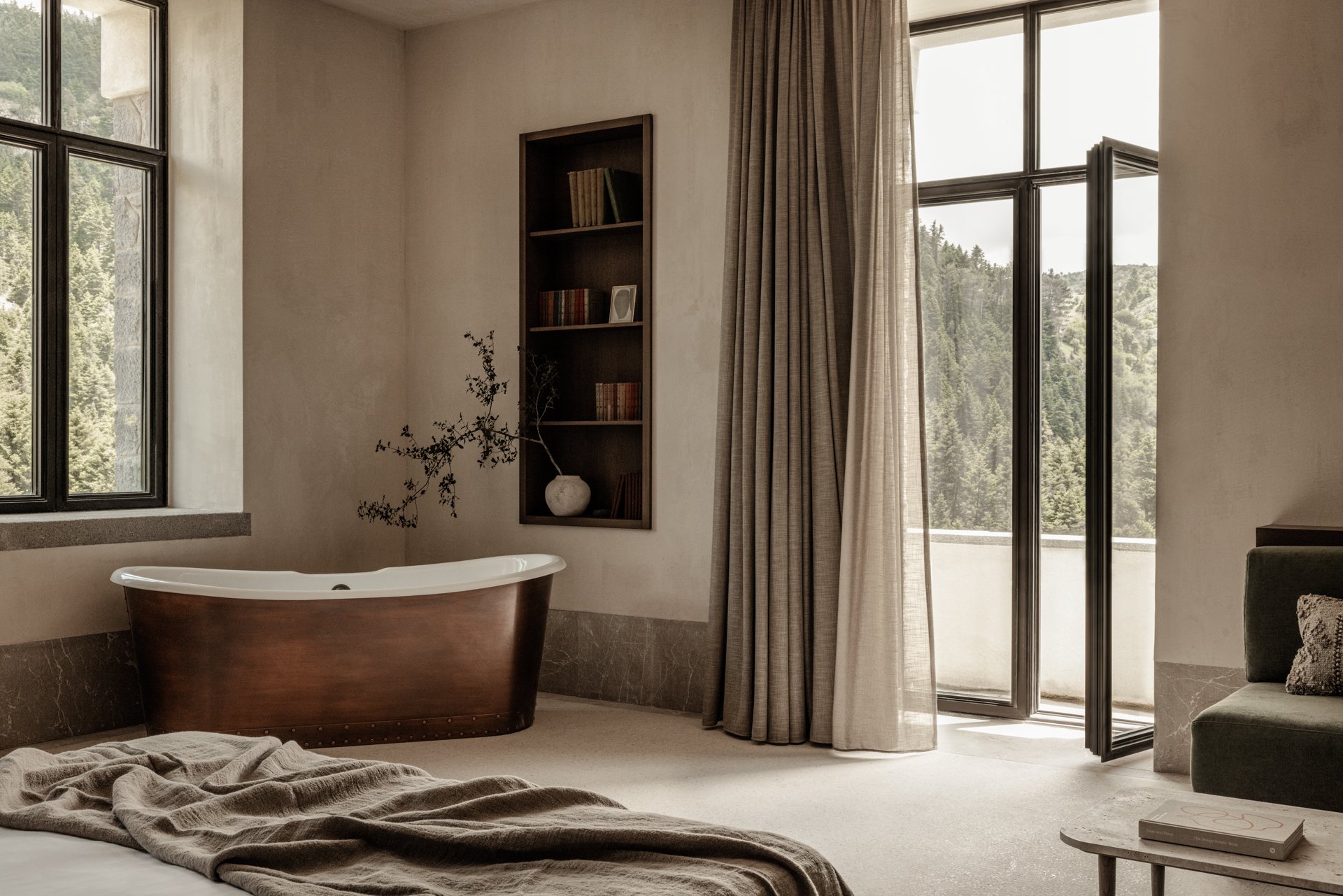 Manna guest room with a freestanding soaking tub and forest views