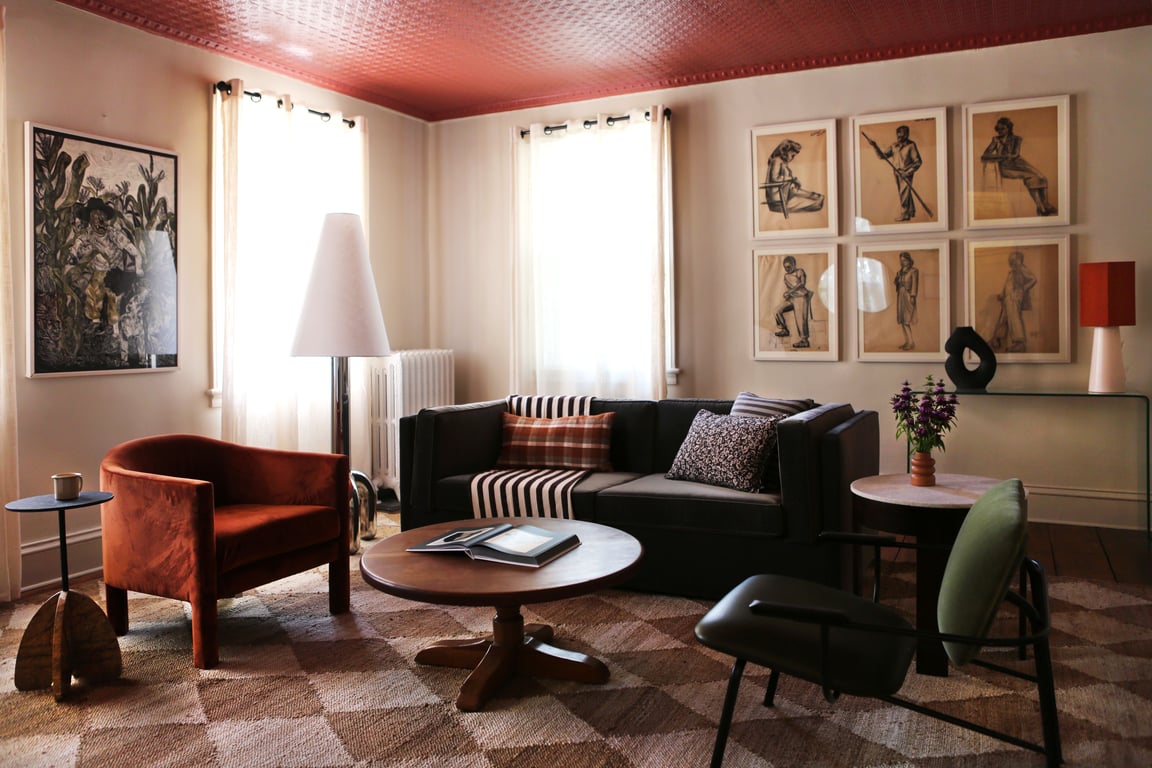 Art-filled sitting room with a red ceiling at Kingston Carriage House